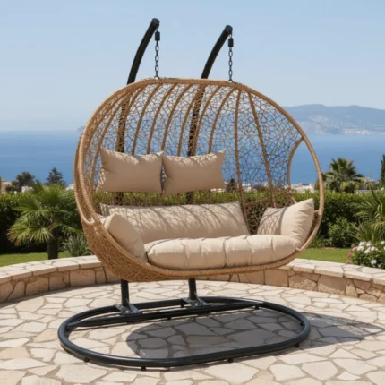Balançoire Orvella design 2 places avec coussin beige sur terrasse moderne, cadre métal noir et panier en rotin synthétique