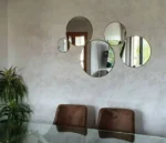 Vue légèrement de côté d’un ensemble de 5 miroirs ronds en laiton doré, décoration murale élégante pour salon marocain ou intérieur moderne