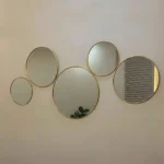 Vue de face d’un ensemble de 5 miroirs ronds en laiton doré, décoration murale élégante pour salon marocain ou moderne