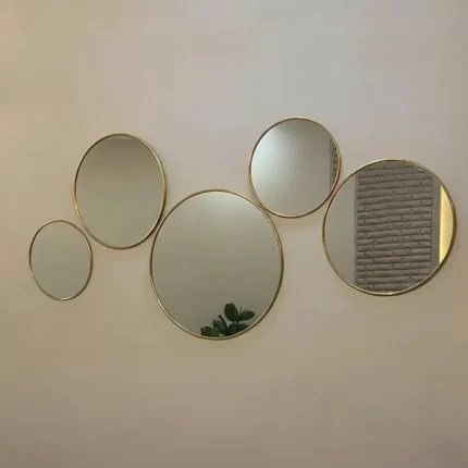 Vue de face d’un ensemble de 5 miroirs ronds en laiton doré, décoration murale élégante pour salon marocain ou moderne