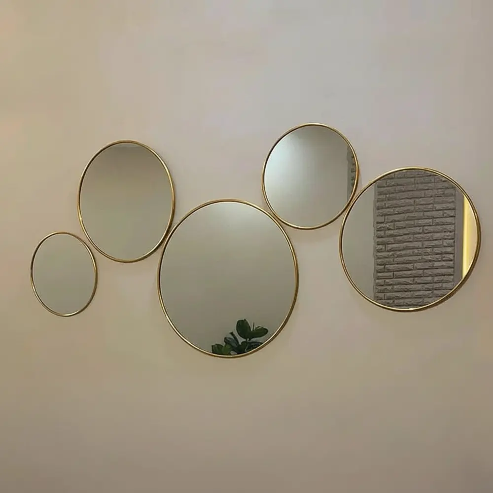Ensemble de 5 miroirs ronds en laiton – Vue de face pour décoration murale élégante au style marocain moderne Vue de face d’un ensemble de 5 miroirs ronds en laiton doré, décoration murale élégante pour salon marocain ou moderne