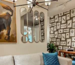 Ensemble de 9 miroirs en laiton, vue légèrement de côté, installé dans un salon, décoration murale élégante et moderne