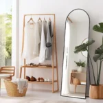 miroir rectangulaire Arco avec cadre métallique antirouille et sommet cintré, exposé à côté d’un portant à vêtements, design moderne pour chambre ou dressing
