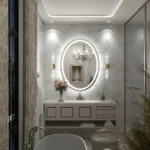 Miroir ovale LED sablé OVALIA SAND installé au-dessus d’un vasque blanc dans une salle de bain moderne