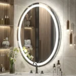 Miroir ovale sablé avec éclairage LED au-dessus d’un meuble vasque en bois clair