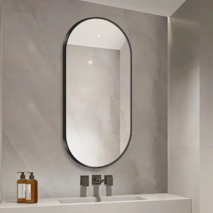 miroir semi-ovale cadre métal antirouille vu légèrement de biais, design moderne et résistant à l’humidité
