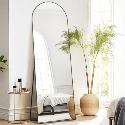 miroir rectangulaire sur pied avec cadre métallique antirouille et sommet cintré, vue légèrement de côté, design moderne pour chambre ou salon