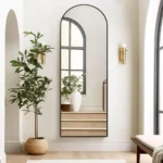 miroir rectangulaire avec cadre métallique antirouille et sommet cintré, accroché verticalement au mur, vue en face, style moderne pour chambre ou salon