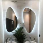 Deux miroirs LUMIRIS rétroéclairés au design irrégulier et inversé, installation moderne sur mesure pour salle de bain au Maroc