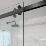 Détail de la porte coulissante d'une cabine de douche rectangulaire, rail en finition noir mat